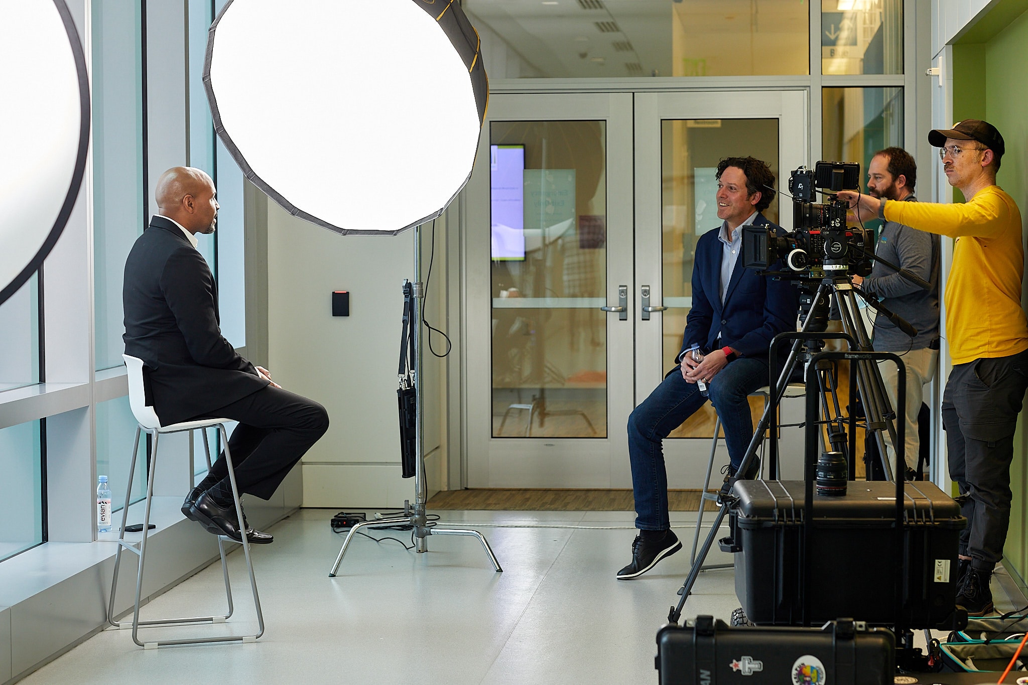 Film crew recording interview with man