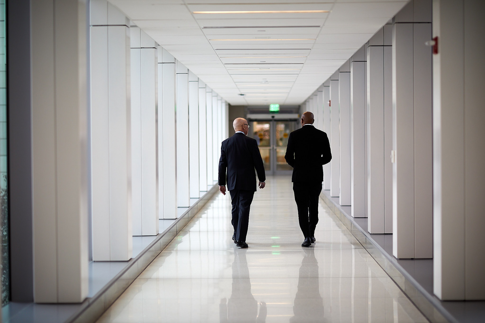 Businessmen walking modern office corridor
