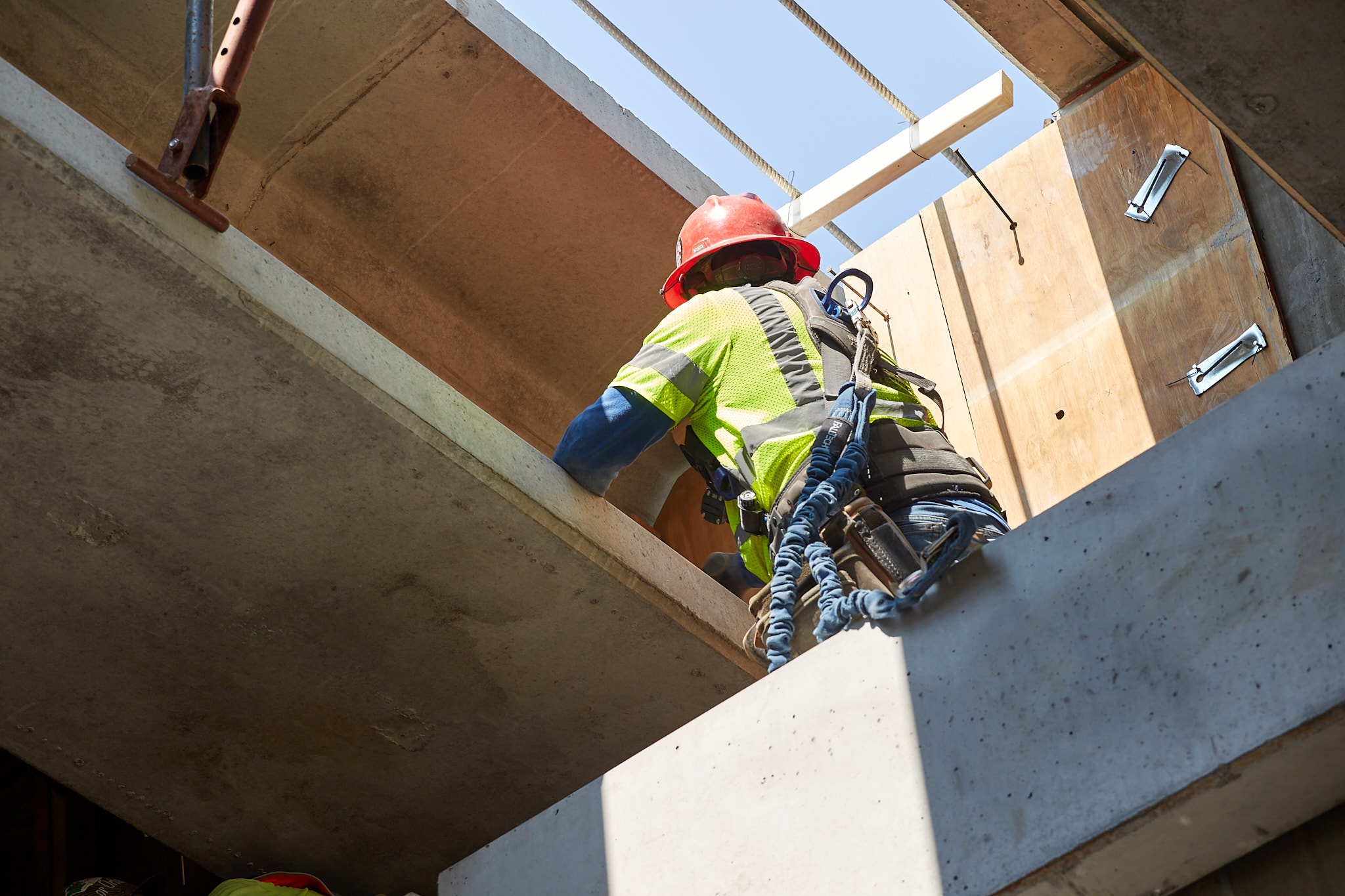 Construction worker climbing concrete structure