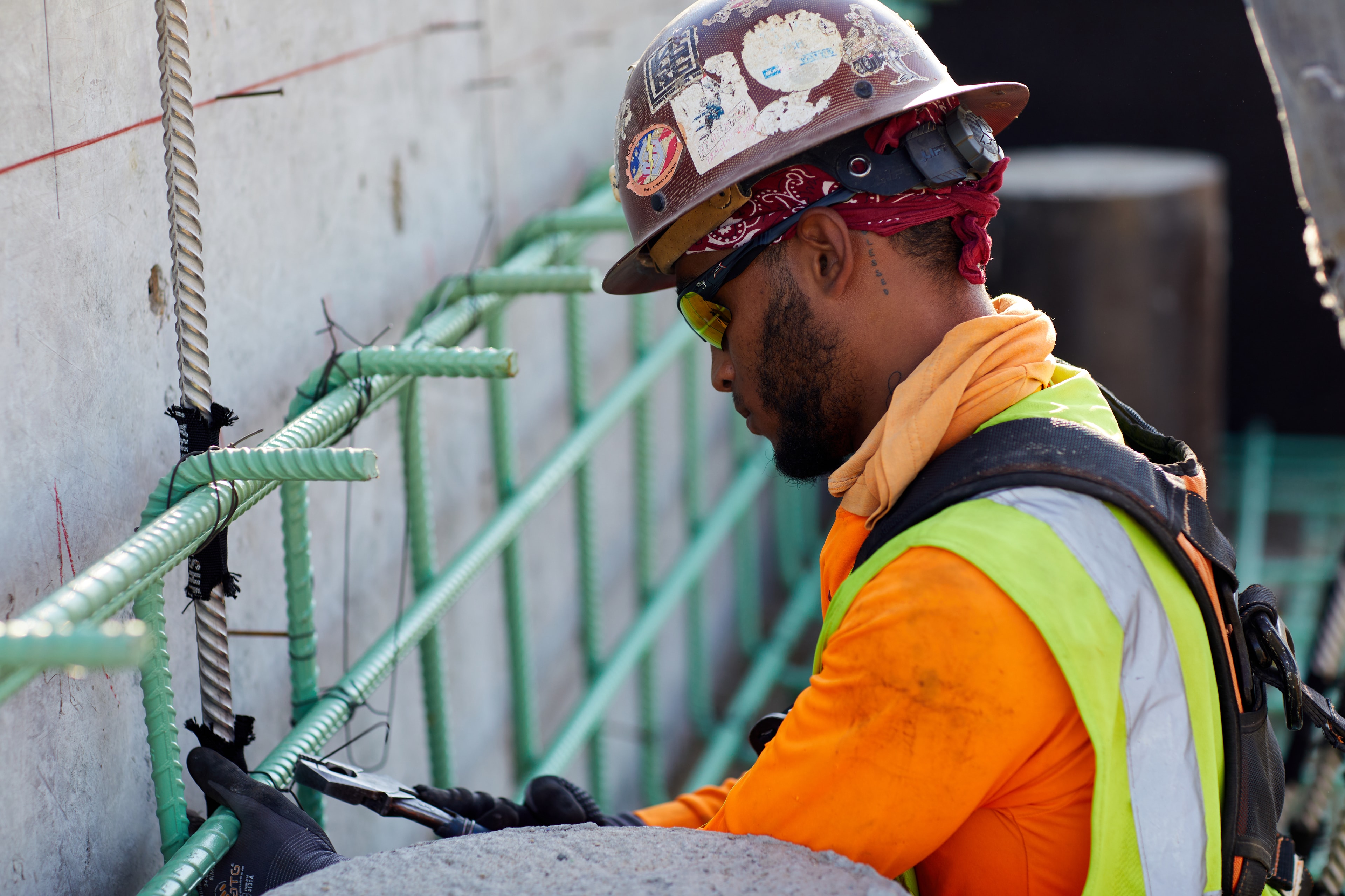 Construction worker installing green conduit pipes