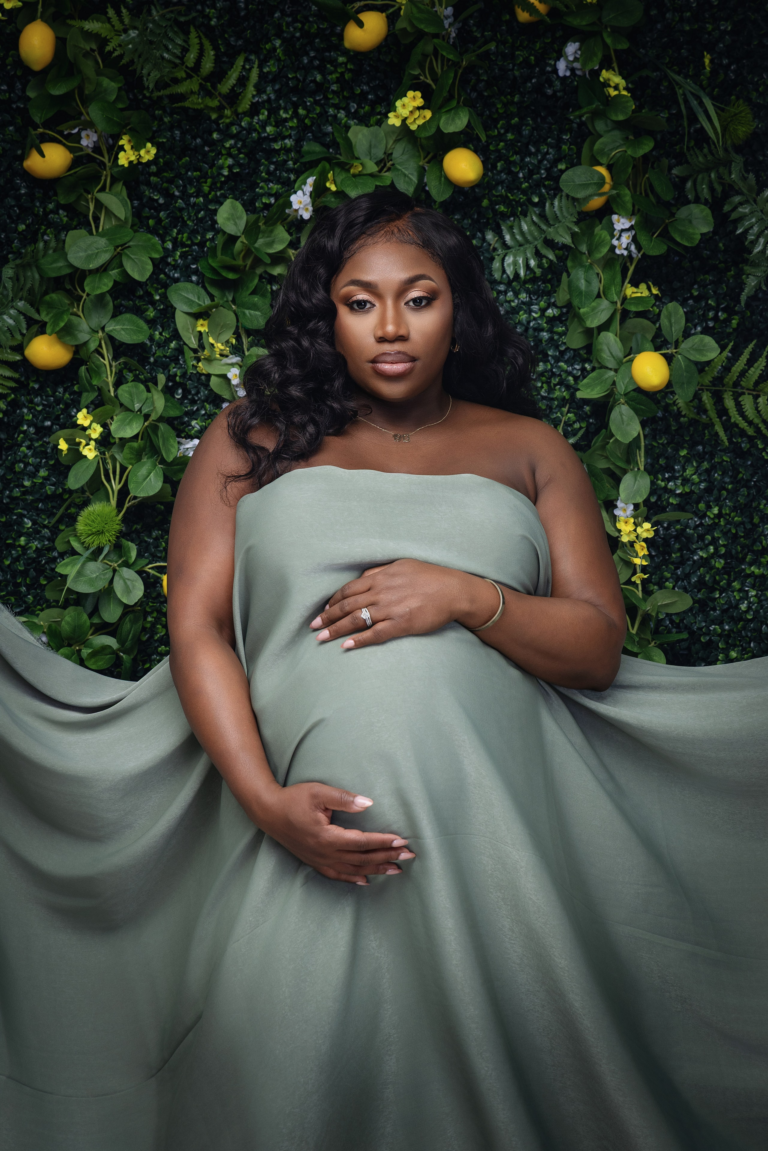 Pregnant woman posing against floral backdrop
